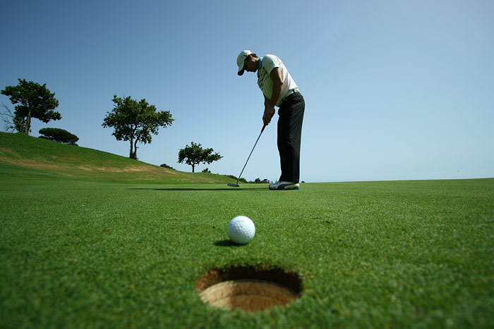 Golfer lines up a putt. 